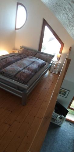 a bedroom with a large bed with a wooden floor at SECRA Exclusive Maisonette-Ferienzimmer Am Backhausgarten in Flonheim