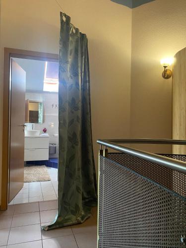 a bathroom with a shower curtain and a sink at SECRA Exclusive Maisonette-Ferienzimmer Am Backhausgarten in Flonheim