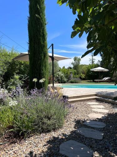 un jardin avec piscine et aménagement paysager dans l'établissement Charming Provençal farmhouse with pool, à Mérindol