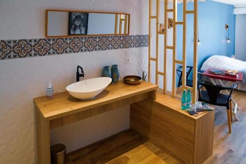 a bathroom with a bowl sink on a wooden counter at Aquabella in Aiguebelette-le-Lac