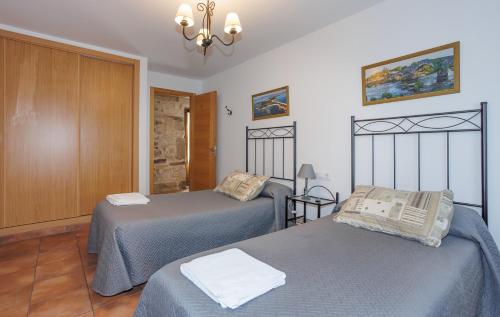 a room with two beds and a chandelier at Alojamiento Pazos in Cea