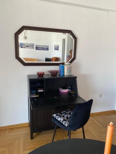 a black dresser with a mirror and a chair at SEAVIEW KAVALA PORT in Kavala