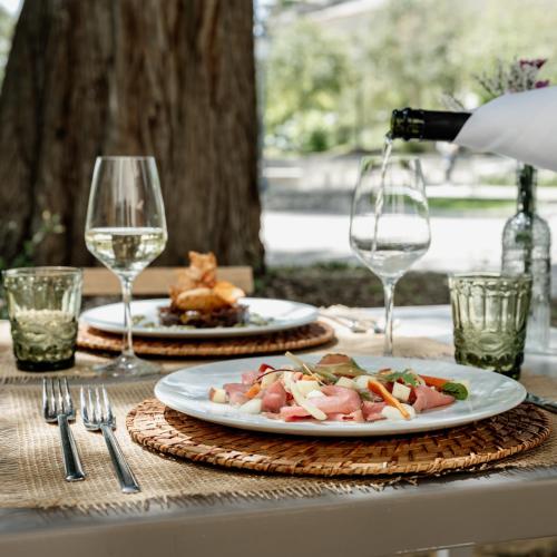 a table with two plates of food and wine glasses at Antico Convento Dei Cappuccini in Ragusa