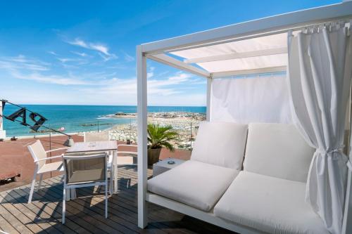 a balcony with a couch and a table and the ocean at Park Hotel Cattolica & Restaurant in Cattolica
