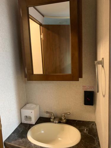 a bathroom with a sink and a mirror and aounter sidx sidx sidx at Zhangjiajie Cliff Flower RV Tent Hotel in Sanguansi