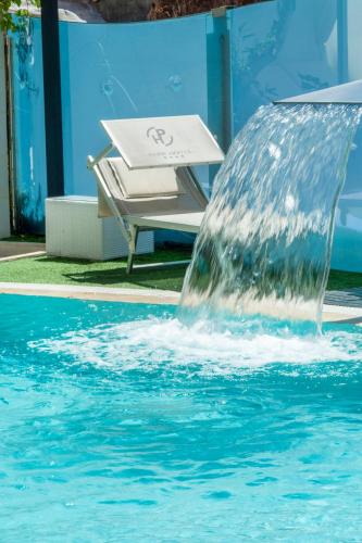 a water fountain in a swimming pool with a bench at Park Hotel Cattolica & Restaurant in Cattolica