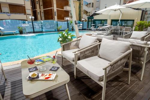 a table and chairs next to a swimming pool at Park Hotel Cattolica & Restaurant in Cattolica