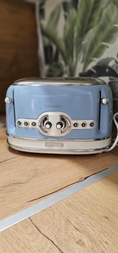 a blue toaster sitting on top of a wooden table at Péterfia Boutique Apartments in Debrecen