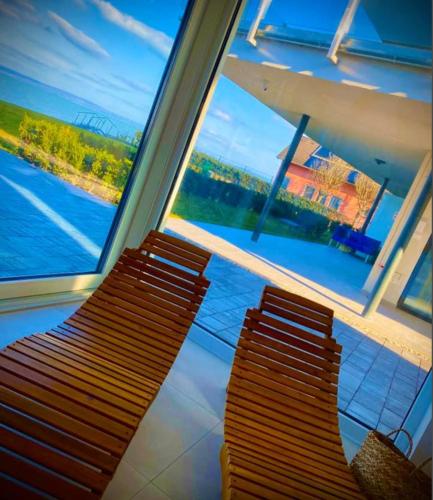 two benches sitting next to a window on a train at Infinity Apartman Lellemarine in Balatonlelle