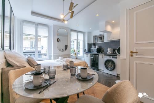 une cuisine et un salon avec une table et des chaises dans l'établissement MBA - Louvres - Luxury Appartement, à Paris
