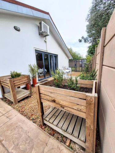 two wooden benches sitting outside of a house at 9 on Drommedaris in Stellenbosch