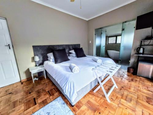 a bedroom with a large white bed and wooden floors at 9 on Drommedaris in Stellenbosch
