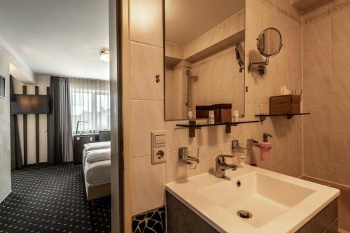 a bathroom with a sink and a mirror at Hotel Ochsen in Bad Saulgau