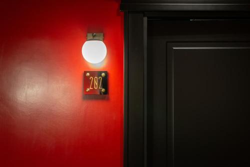 a light on a red wall with a switch at The Couper Umiltà in Rome