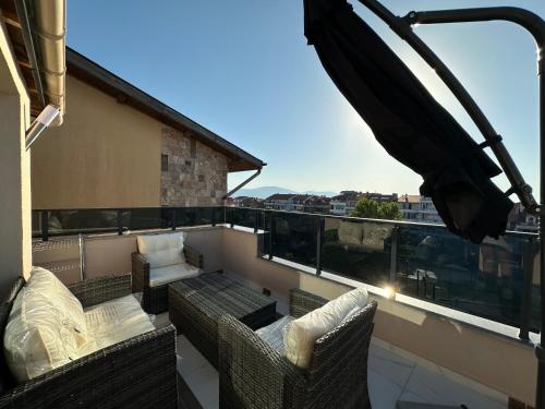 a balcony with chairs and a couch on a building at Alta Vista Apollonia in Sozopol