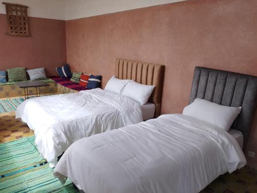 a bedroom with two beds and a table at Riad & Restaurant Ocean Beach Douira in Agadir