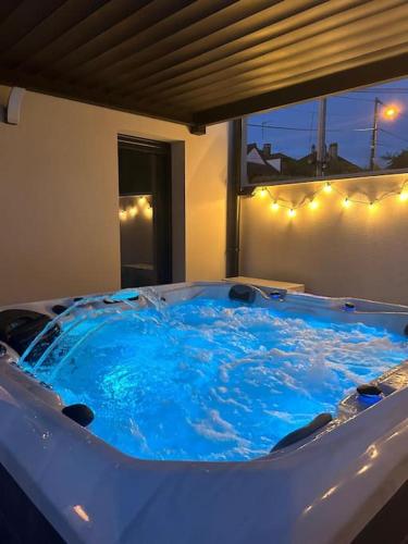 - un grand bain à remous bleu dans l'établissement LOFT & SPA, aux Portes de Disneyland et de Paris, à Saint-Thibault-des-Vignes