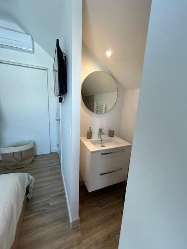 une salle de bain blanche avec un lavabo et un miroir dans l'établissement LOFT & SPA, aux Portes de Disneyland et de Paris, à Saint-Thibault-des-Vignes