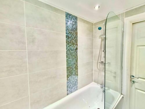 a bathroom with a tub and a glass shower at Liverpool 4 Bed Home Sleeps 18 Free Parking in Liverpool
