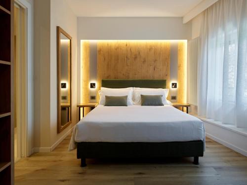 a bedroom with a large bed and a large window at Hotel America in Trento