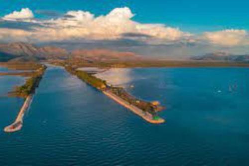 an island in the middle of a body of water at Apartman Antonela in Komin