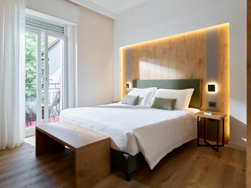 a bedroom with a large bed with a wooden headboard at Hotel America in Trento