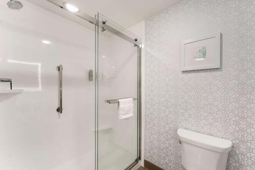a bathroom with a toilet and a glass shower at Hampton Inn Milford in Milford