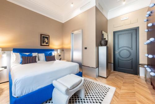 a bedroom with a large bed and a blue door at The Couper Umiltà in Rome