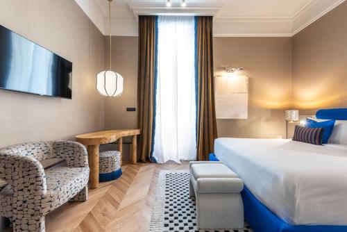 a hotel room with a bed and a chair at The Couper Umiltà in Rome