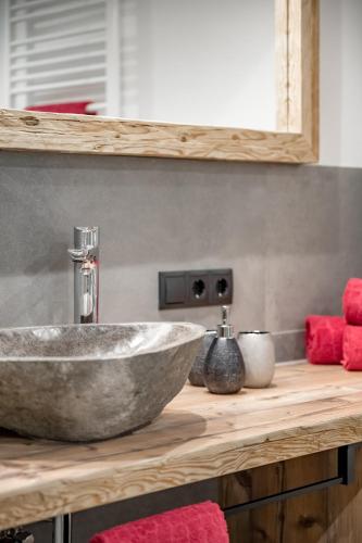 a bathroom with a stone sink on a wooden counter at Hotel Jägerhof in Kaunertal