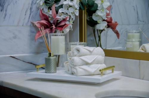 a bathroom sink with towels and flowers in a mirror at Bosque Encantado in Beire