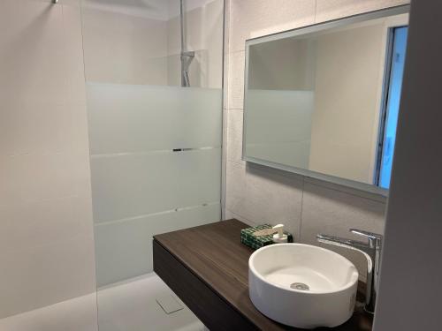 une salle de bain avec un lavabo blanc et un miroir dans l'établissement MIchelet st jacques saxo, à Marseille