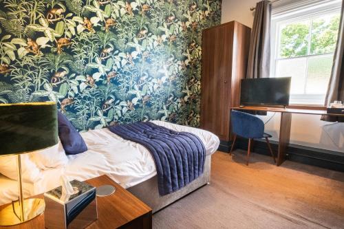 a bedroom with a bed and a desk with a computer at The Coach House Suffolk in Lowestoft
