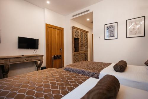 a hotel room with two beds and a television at Shirvanshah Hotel in Baku