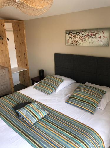 une chambre avec un lit avec deux oreillers dessus dans l'établissement La Hume Vacances, à Gujan-Mestras