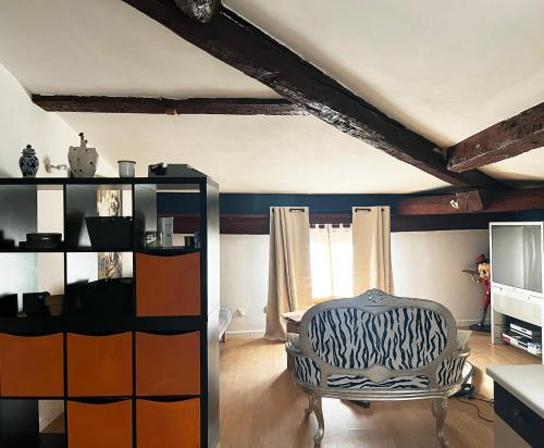 - un salon avec une chaise et une étagère dans l'établissement Location de Vacances à Agde, à Agde