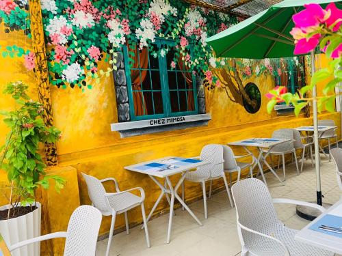 a group of tables and chairs in front of a building at Chez Mimosa Petite - Free Laundry in Ho Chi Minh City