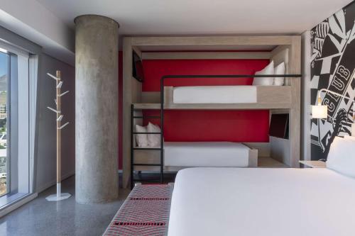a bedroom with two bunk beds and a red wall at Radisson RED Hotel V&A Waterfront Cape Town in Cape Town