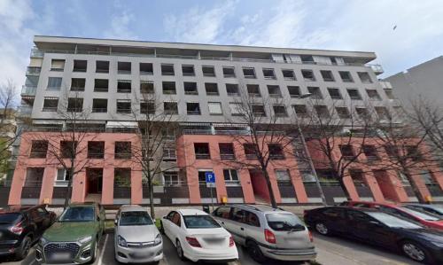 a large building with cars parked in a parking lot at Apartman Vivi in Zagreb