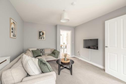 a living room with a white couch and a tv at Windsor 10 Mins - 3 Bedrooms, 2 Bathrooms House with Parking - By Tempstay in Slough