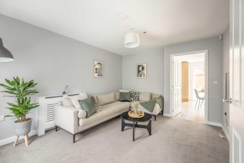 a living room with a couch and a table at Windsor 10 Mins - 3 Bedrooms, 2 Bathrooms House with Parking - By Tempstay in Slough