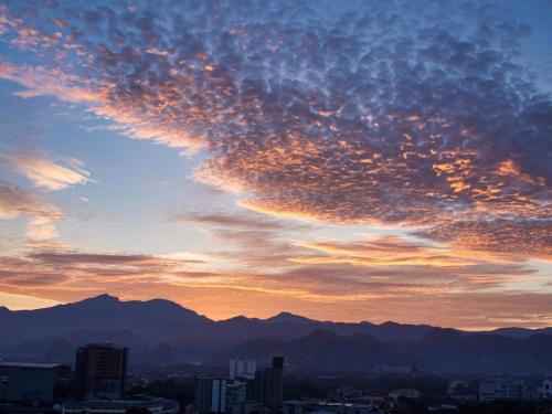 a cloudy sky at sunset with mountains in the background at The Majestic Executive Suite - Ipoh in Ipoh
