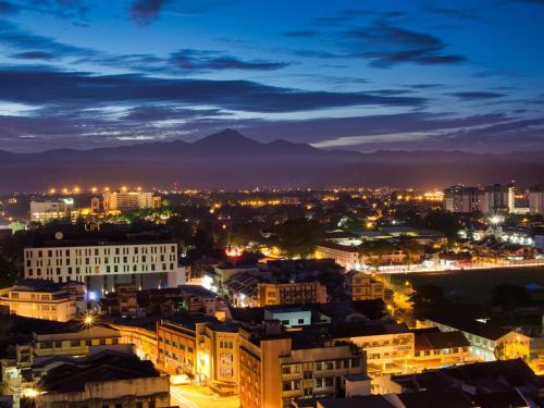 a city at night with mountains in the background at The Majestic Executive Suite - Ipoh in Ipoh