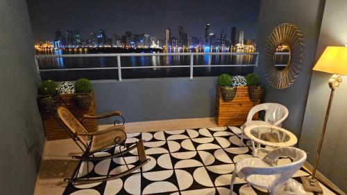 a balcony with chairs and a view of the city at Luxury Private Rooms in Sharjah