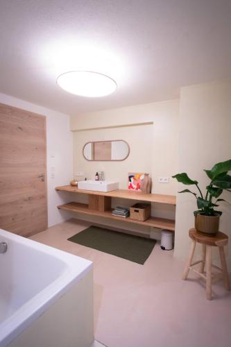 a bathroom with a sink and a mirror and a tub at Schönblick Appartements in Lofer