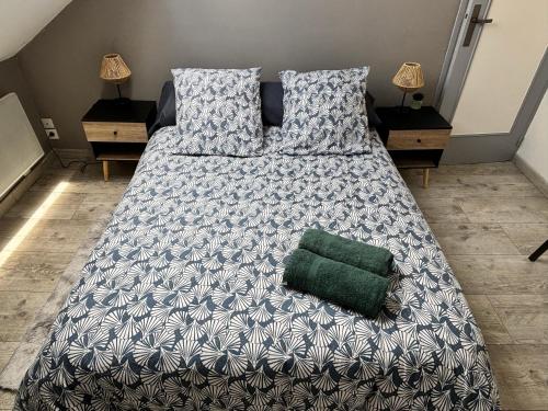 - un grand lit avec un oreiller vert dans l'établissement Proche centre - parking securisé, à Sainte-Savine