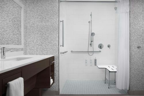 un bagno bianco con doccia e lavandino di Home2 Suites By Hilton Poughkeepsie a Poughkeepsie