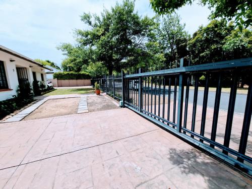 a black fence in front of a driveway at 9 on Drommedaris in Stellenbosch