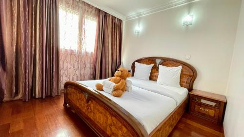 - un ours en peluche assis sur un lit dans une chambre dans l'établissement 108 - Spacieux Appartement de 90m2, à Aubervilliers