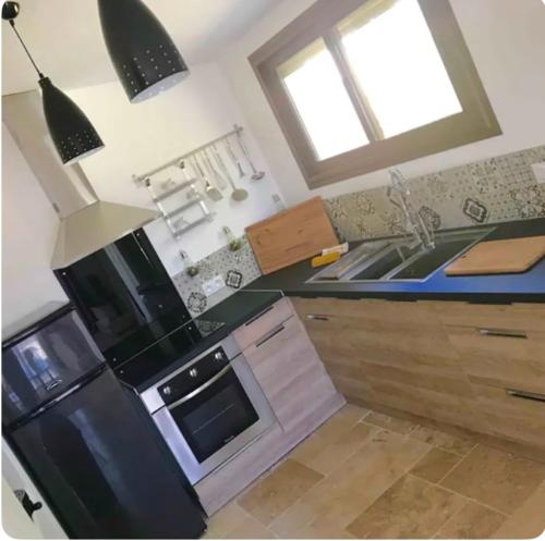 a kitchen with a black refrigerator and a sink at Eco logde & spa in Châteaurenard